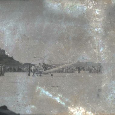 A historic photograph of a crowd by an airfield, showcasing vintage aviation and nostalgia.