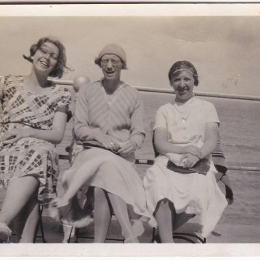 Three women enjoying a seaside trip captured in a vintage style photo.