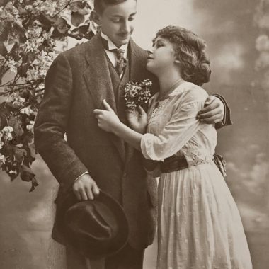 A nostalgic grayscale portrait of an Edwardian couple in an embrace, reflecting timeless romance.